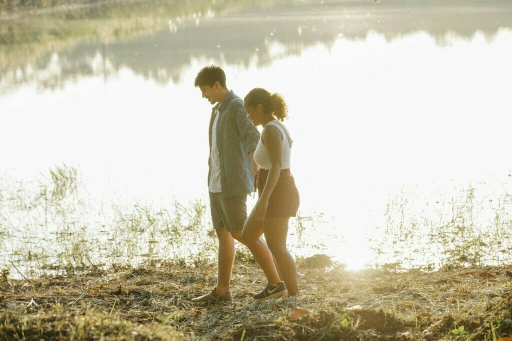Be Heard | curaJOY Content young multiethnic couple holding hands while waling on lake shore at sunset