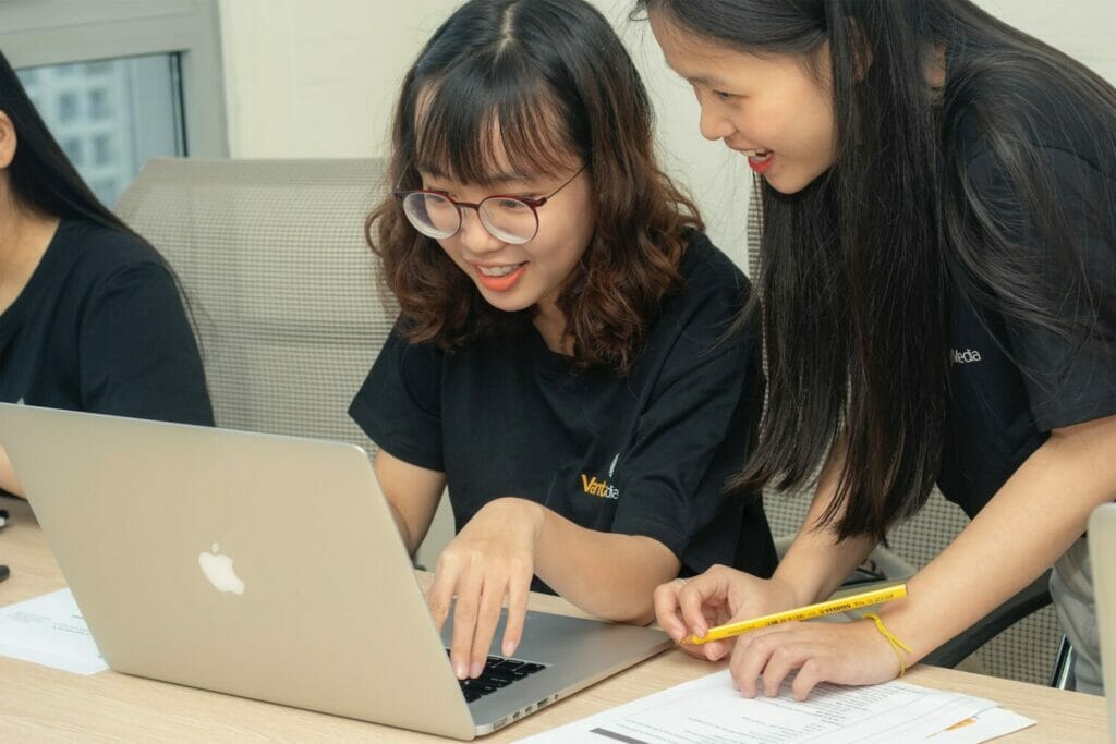 Asian | curaJOY Three Asian women working on a laptop, promoting youth wellness and parenting.